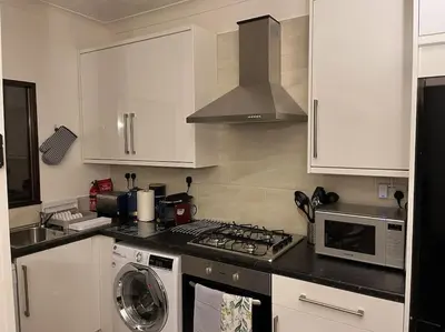 a kitchen with a stove top oven and a microwave at The Nook Crieff - central 2-bed with garden :) in Crieff