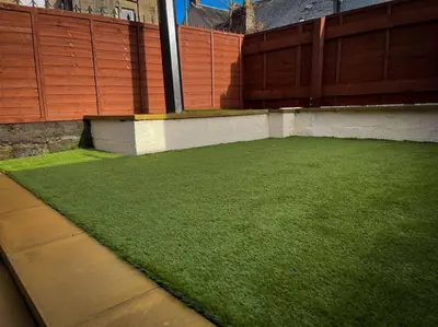 a patch of green grass on the side of a building at The Nook Crieff - central 2-bed with garden :) in Crieff