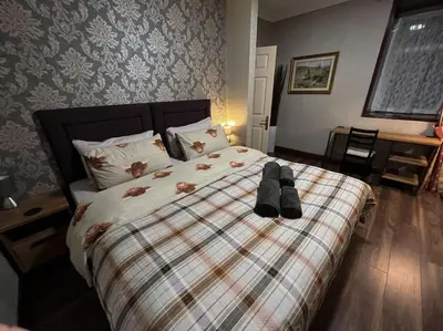a bedroom with a large bed with shoes on it at The Nook Crieff - central 2-bed with garden :) in Crieff