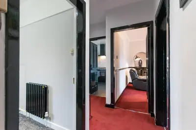 a hallway with a door leading to a living room at Cosy & Central 2BD Apartment Milngavie, Glasgow in Milngavie
