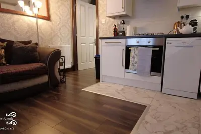a kitchen with white appliances and a couch in a room at The Wee Nook Crieff - 1-bed with garden :) in Crieff