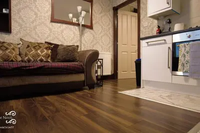 a living room with a couch and a kitchen at The Wee Nook Crieff - 1-bed with garden :) in Crieff