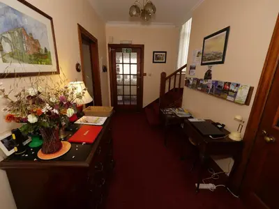 a room with a desk with a vase of flowers on it at Belvedere in Brodick