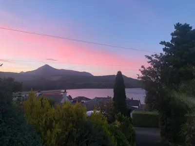 a view of a lake and mountains at sunset at Belvedere in Brodick