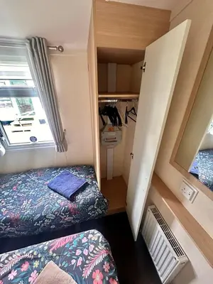 a small room with two beds and a closet at Swift Moselle 2 Bedroom Caravan Located in Uddingston, Glasgow at Maryville Caravan Site in Uddingston