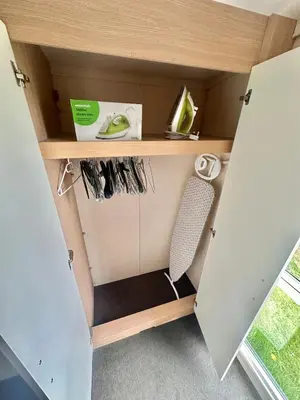 a small cabinet with a chair in a room at Swift Moselle 2 Bedroom Caravan Located in Uddingston, Glasgow at Maryville Caravan Site in Uddingston