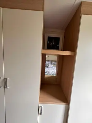 a cupboard with wooden shelves and a small picture at Swift Moselle 2 Bedroom Caravan Located in Uddingston, Glasgow at Maryville Caravan Site in Uddingston