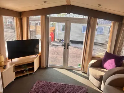 a living room with a flat screen tv and a couch at Swift Moselle 2 Bedroom Caravan Located in Uddingston, Glasgow at Maryville Caravan Site in Uddingston