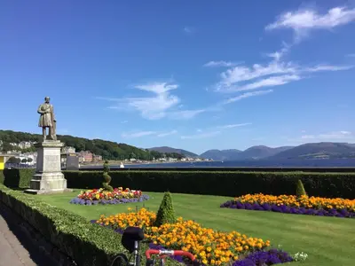 a statue in a garden with flowers at Chapelhill Hideaway Isle of Bute licence AR00654F in Rothesay