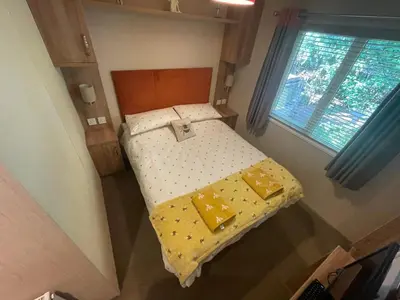 a small bed in a small room with a window at Silver Birch Lodge in Auchterarder