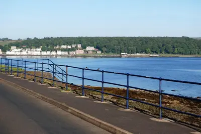 a blue railing next to a body of water at The Ardyne Guest House in Rothesay
