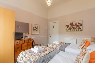 a bedroom with two beds and a dresser at The Ardyne Guest House in Rothesay