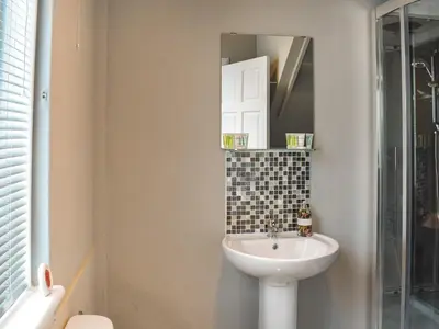 a bathroom with a sink and a mirror at Winlocke Cottage in Leadhills