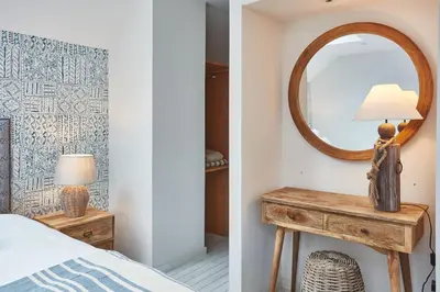a bedroom with a mirror and a table with a lamp at Beach House in Pennygown