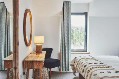 a bedroom with a bed and a desk and a window at Beach House in Pennygown