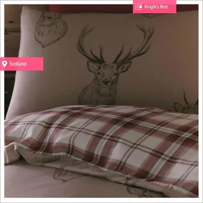a picture of a deer head on a bed at Knight's Rest Guest House in Airdrie
