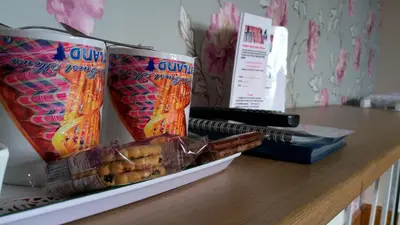 a table with two soda cans and a box of snacks at Knight's Rest Guest House in Airdrie