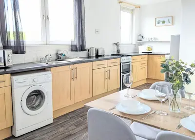 a kitchen with a table and a washing machine at Campbeltown Loch in Campbeltown