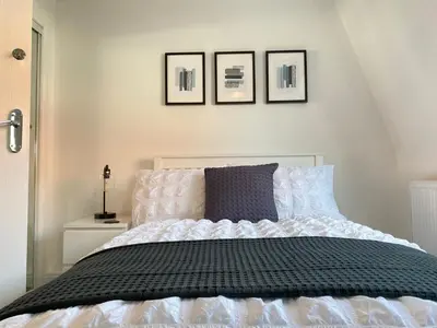 a bedroom with a bed with four pictures on the wall at 3 bedroom - 2 bathroom Townhouse in Corstorphine Near Murrayfield Stadium - Direct Bus To Edinburgh City Centre in 20 Minutes - Two Private Parking Spaces - Private Sunny Garden - Recently Refurbished in Edinburgh