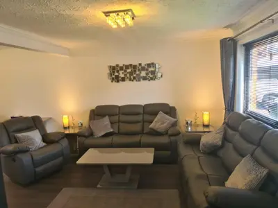 a living room with a couch and a table at Travel Host 3 BEDROOM HOUSE WITH FREE PARKING in Nitshill