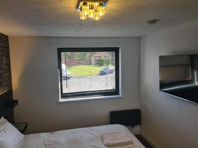 a bedroom with a bed and a window at Travel Host 3 BEDROOM HOUSE WITH FREE PARKING in Nitshill