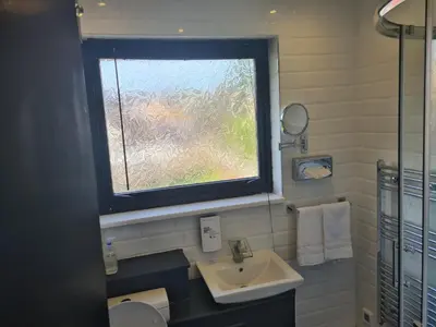 a bathroom with a sink and a window at Travel Host 3 BEDROOM HOUSE WITH FREE PARKING in Nitshill