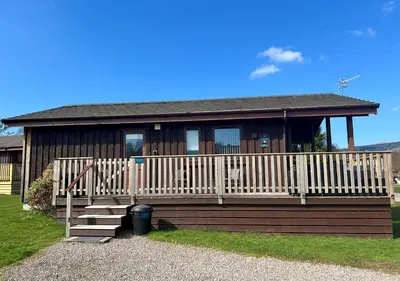 a small house with a porch and stairs to it at Blairlagan Lodge in Hunters Quay