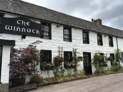 a white building with flower boxes on the side of it at The Winnock Hotel in Drymen