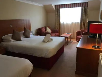 a hotel room with two beds and a living room at The Winnock Hotel in Drymen