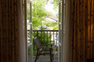 an open door with a chair on a balcony at The Winnock Hotel in Drymen