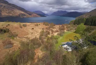 an aerial view of a house on a hill next to a lake at Port na Mine in Bonawe