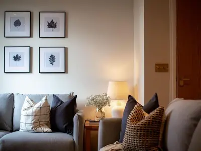 a living room with a couch and pictures on the wall at Stunning 2 bed flat with parking, and garden with mountain views in Crieff
