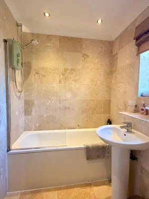 a bathroom with a tub and a sink and a shower at Cosy 2 bedroom home with free parking near city in Edinburgh