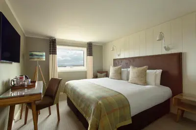 a hotel room with a large bed and a desk at Isle Of Mull Hotel and Spa in Craignure