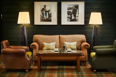 a living room with a couch and a table and two chairs at Isle Of Mull Hotel and Spa in Craignure
