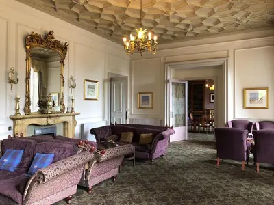 a living room with purple couches and a mirror at Stonefield Castle Hotel ‘A Bespoke Hotel’ in Stonefield