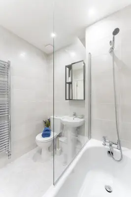 a white bathroom with a toilet and a sink at Mhuilinn Apartment in Stirling