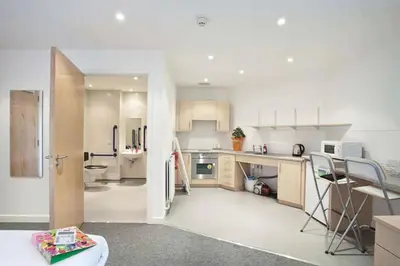 a kitchen with white cabinets and a refrigerator at Edinburgh College Residence in Edinburgh