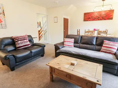 a living room with two leather couches and a coffee table at Barley Cottage in Newton Stewart