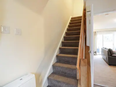 a staircase in a living room with a couch at Barley Cottage in Newton Stewart