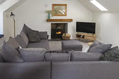 a living room with a gray couch and a fireplace at Stroan in New Galloway