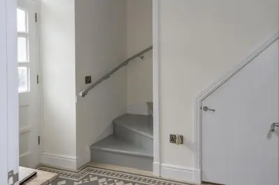 a staircase in a home with white walls and a stair case at Stroan in New Galloway