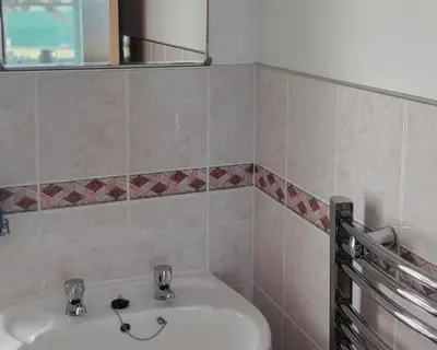 a bathroom with a sink and a mirror at Blaeberry Cottage in Killean
