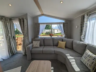 a living room with a couch and a large window at The Castleton 20 in Ardentinny