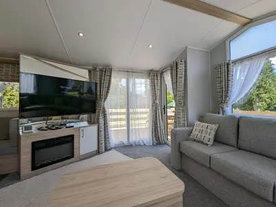 a living room with a couch and a flat screen tv at The Castleton 20 in Ardentinny
