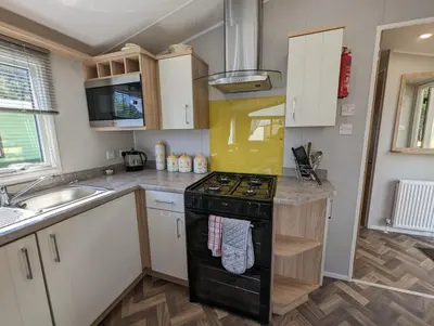 a kitchen with a black stove and a sink at The Castleton 20 in Ardentinny