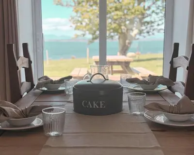 a dining table with a cake pot on top of it at Primrose Cottage in Killean