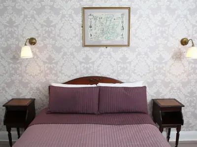 a bedroom with a bed with two nightstands and two lamps at Glasgow city Charlotte service Aparments in Glasgow