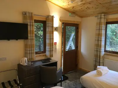 a room with a bed and a desk and a tv at Rowardennan Hotel in Rowardennan