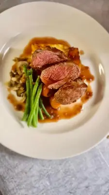 a plate of food with meat and vegetables on a table at Rowardennan Hotel in Rowardennan